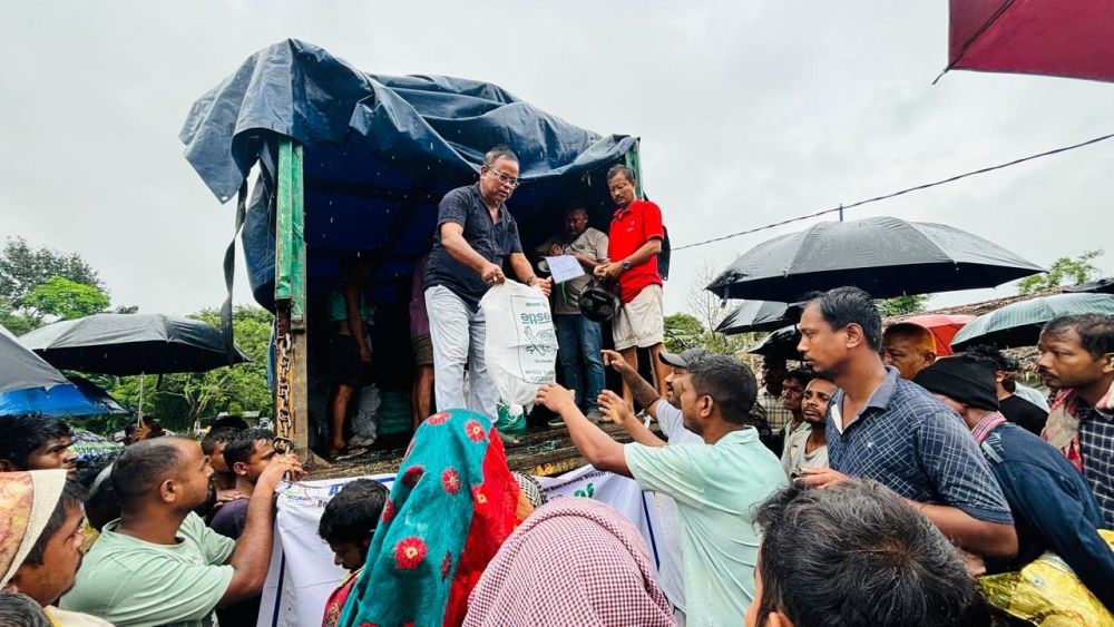 Officials hand over the relief material during the flood relief distribution at Charaideo in Assam.
